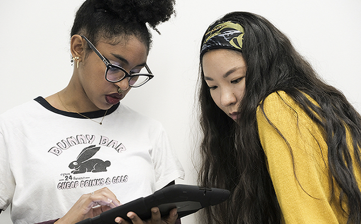 Two students looking at computing device